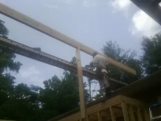 Carpenter setting a ridge beam over a new addition frame — Ice Dam Removal by Roofing Brothers in Ferrum