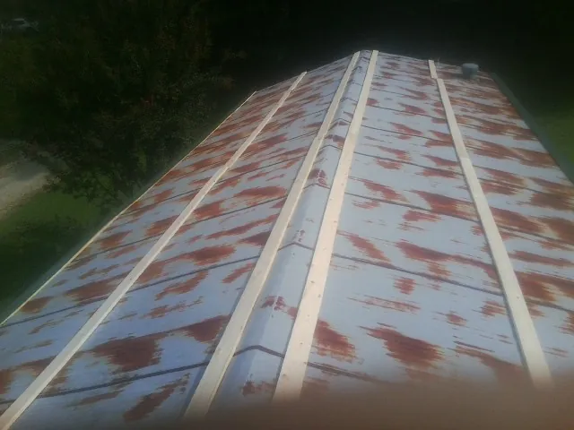 Rusted metal roof panels with new wood purlins before replacement — Storm Damage Roof Repair in Ferrum by Roofing Brothers