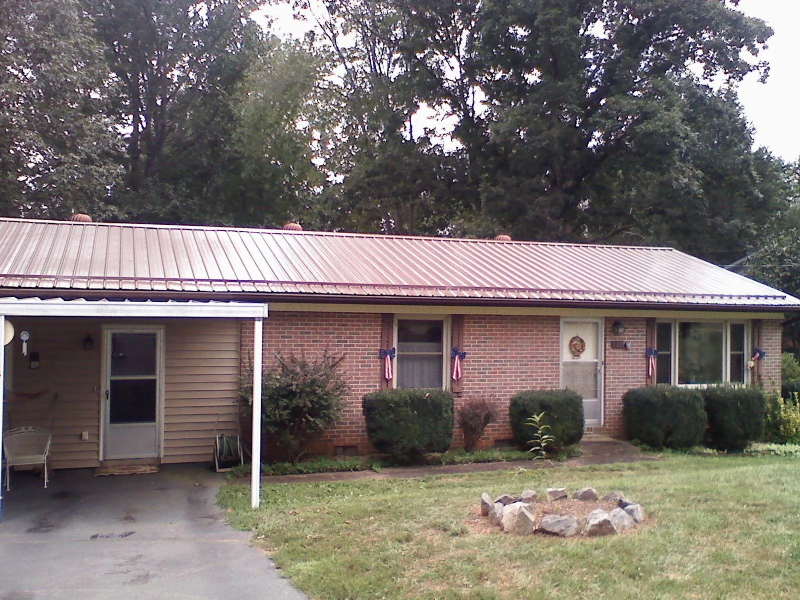 Bronze metal roof and carport on a brick ranch home — Roof Repair work by our crew in Ferrum