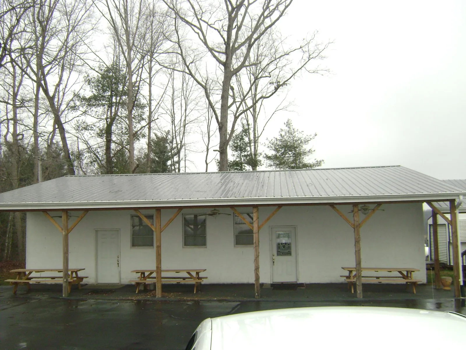 Gray metal roof over a block building with a timber post porch in Ferrum