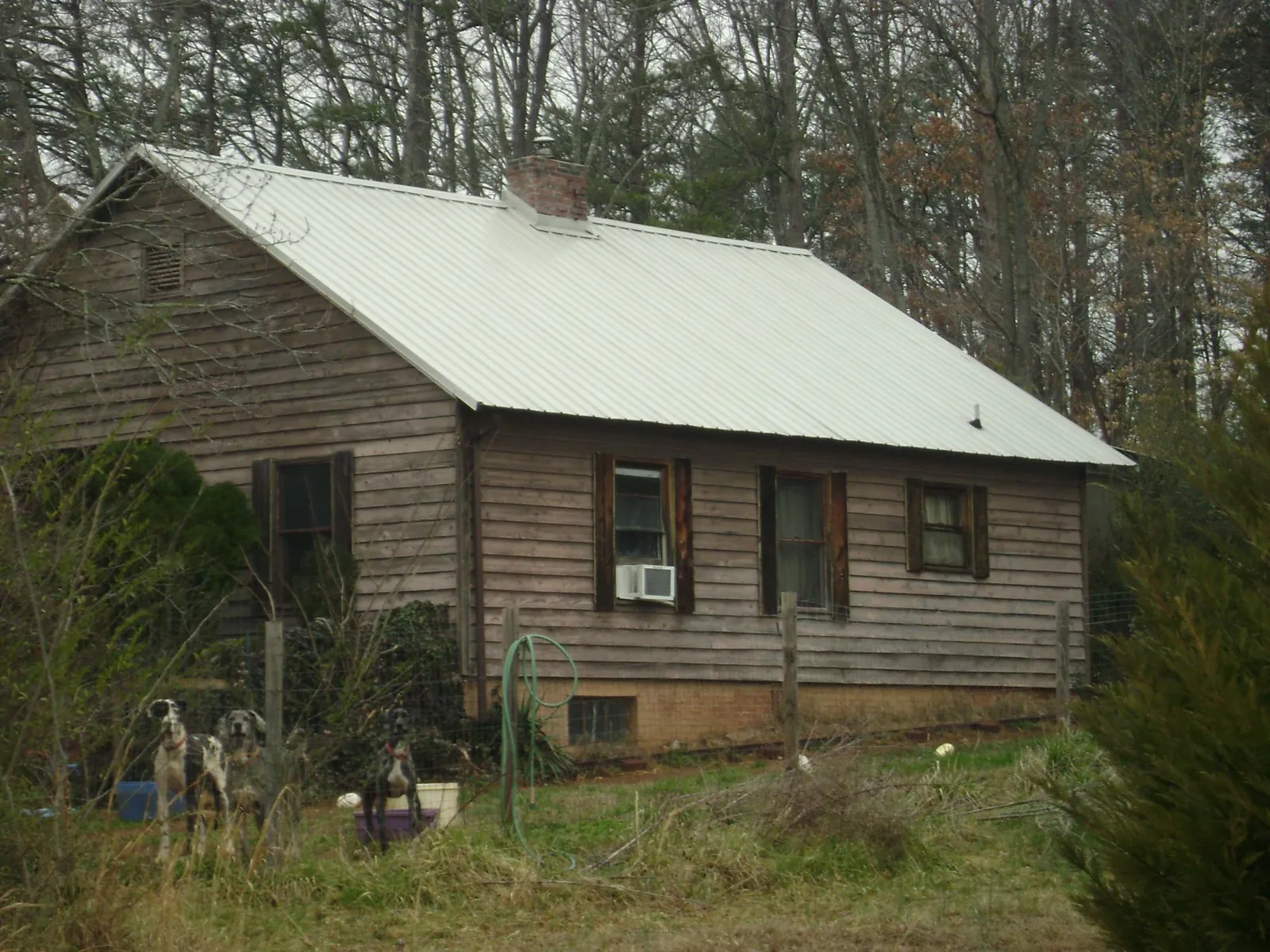 White metal roof on an old wood sided farmhouse, from a Asphalt Shingle Roof Repair job in Ferrum